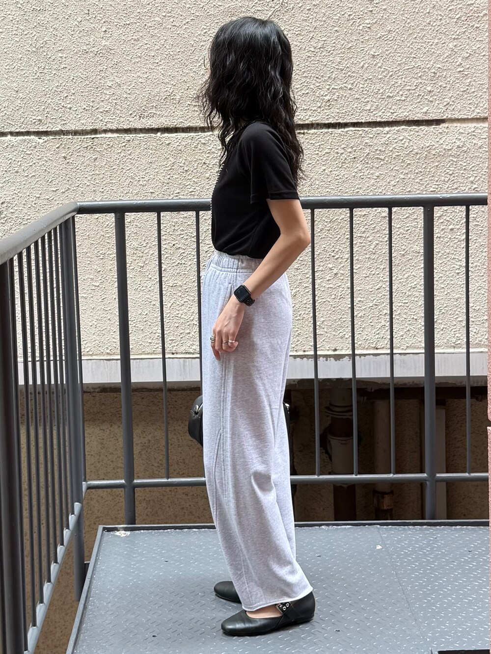 グレー系のその他パンツ、ブラック系のTシャツ/カットソー、ブラック系のショルダーバッグを着用したレディースの夏コーディネートの2枚目の写真