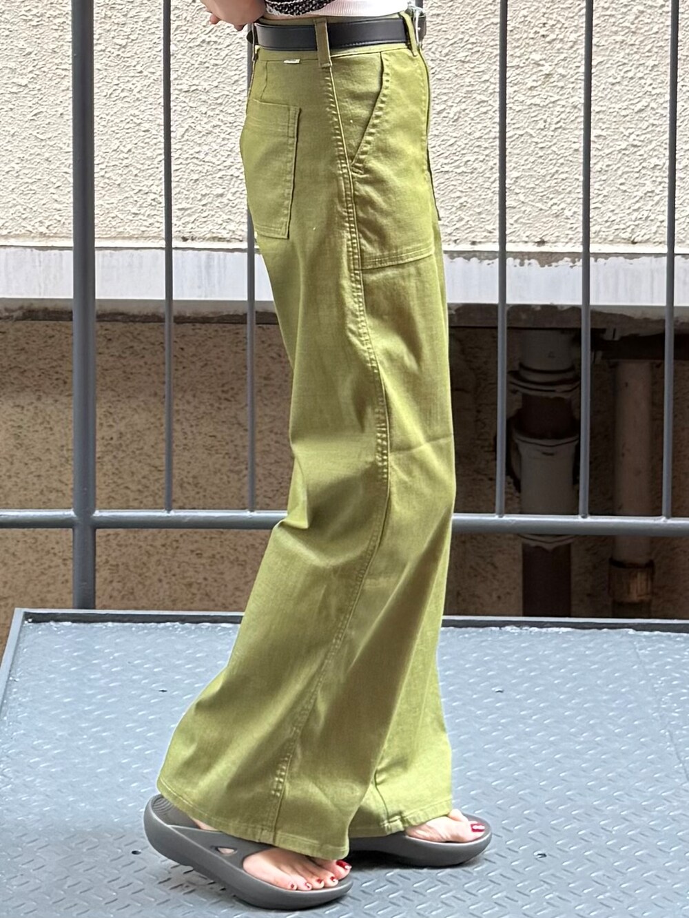 グリーン系のその他パンツ、ブラック系のシャツ/ブラウス、グレー系のサンダルを着用したレディースの夏コーディネートの6枚目の写真