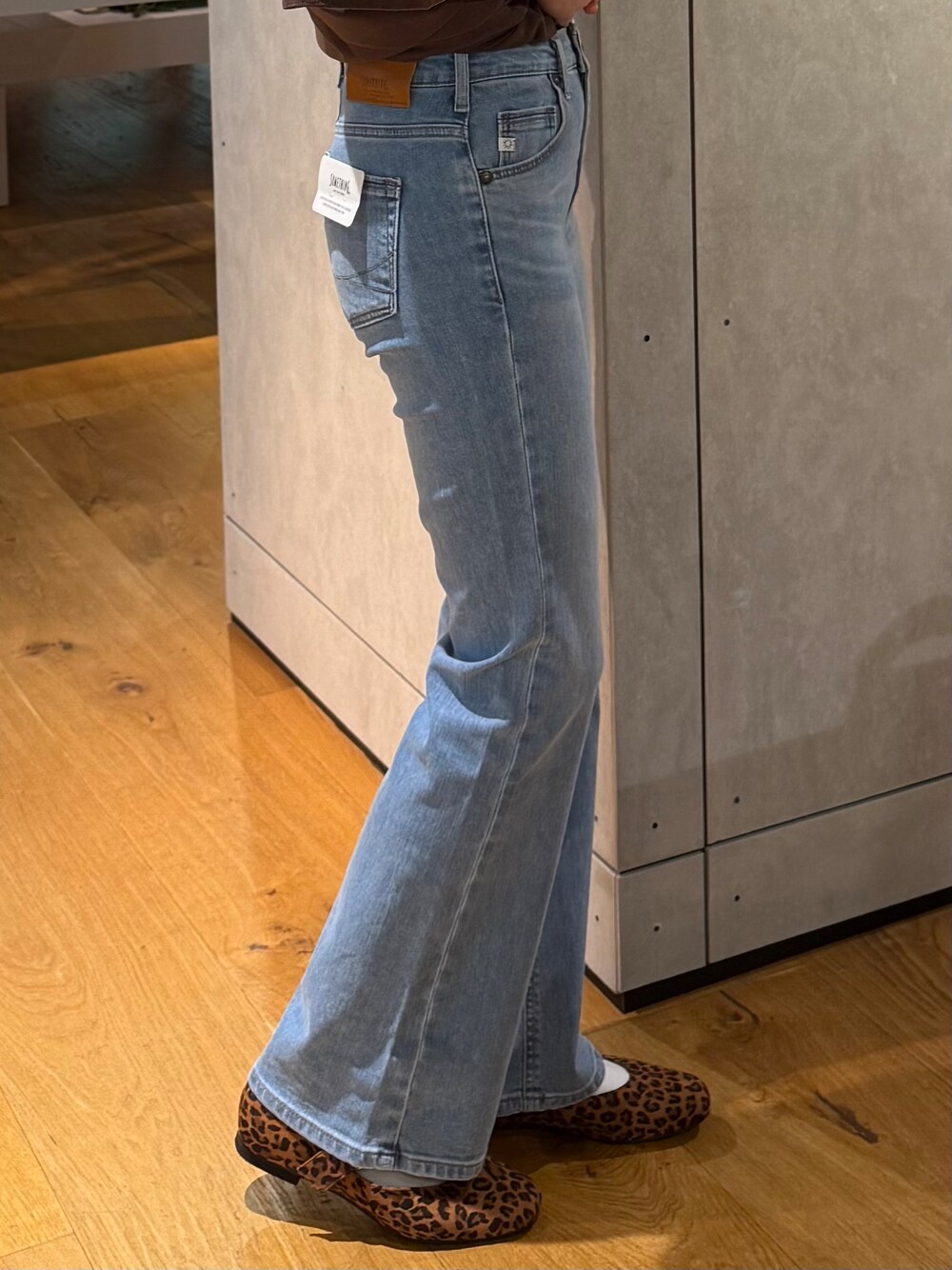 ブルー系のデニムパンツ、ホワイト系のベスト、ブラウン系のTシャツ/カットソーを着用したレディースの夏コーディネートの5枚目の写真