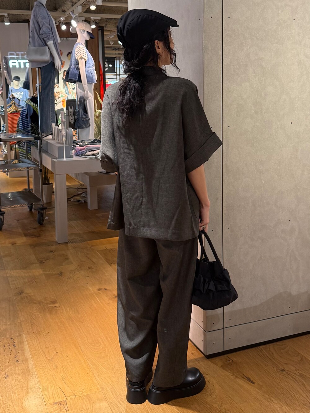 グレー系のその他パンツ、グレー系のテーラードジャケット、ホワイト系のタンクトップを着用したレディースの春コーディネートの2枚目の写真