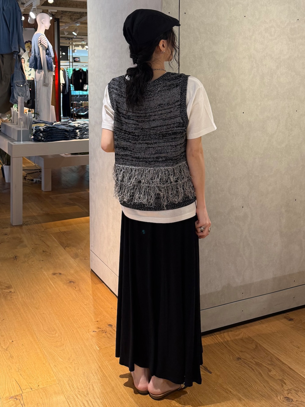 ブラック系のスカート、ブラック系のベスト、ホワイト系のTシャツ/カットソーを着用したレディースの夏コーディネートの3枚目の写真