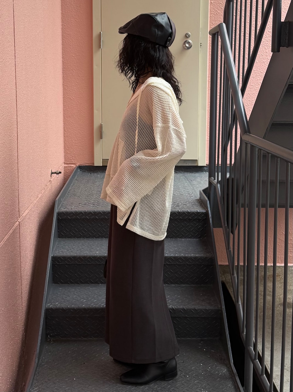 グレー系のスカート、ホワイト系のTシャツ/カットソー、ブラック系のショルダーバッグを着用したレディースの秋コーディネートの2枚目の写真