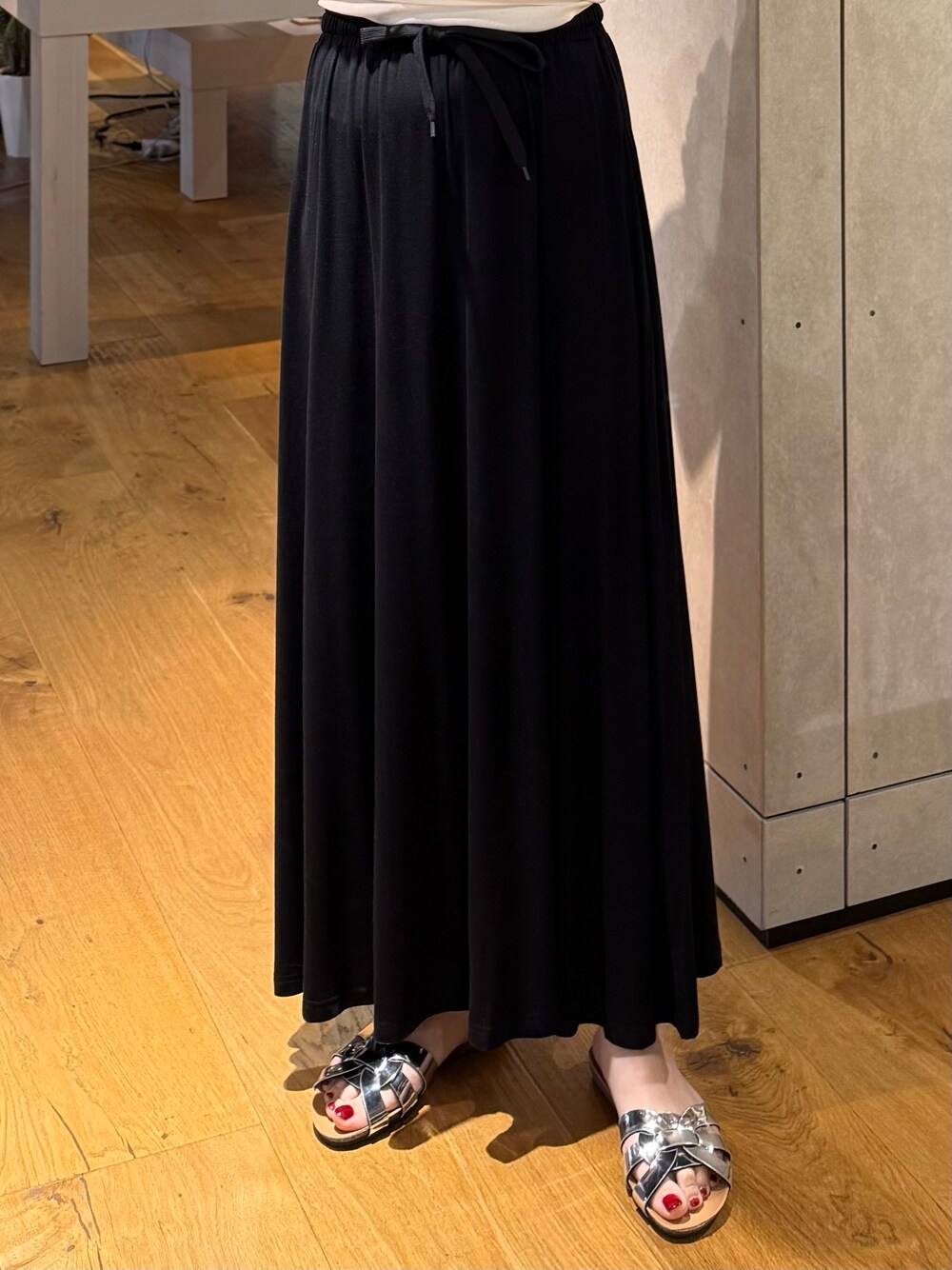 ブラック系のスカート、ブラック系のベスト、ホワイト系のTシャツ/カットソーを着用したレディースの夏コーディネートの5枚目の写真