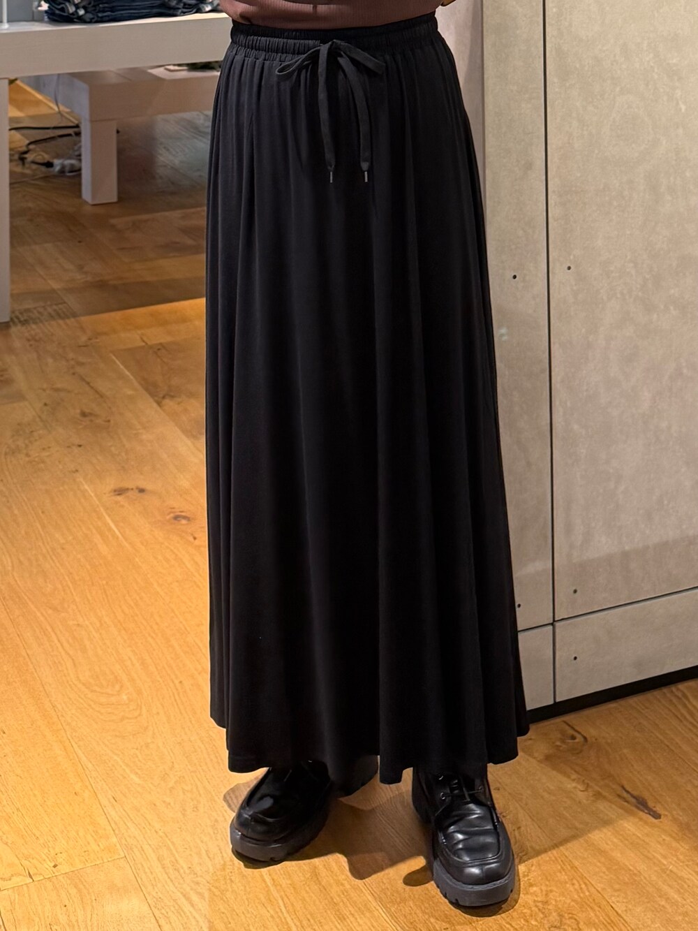 ブラック系のスカート、ブルー系のTシャツ/カットソー、ブラウン系のタンクトップを着用したレディースの夏コーディネートの5枚目の写真