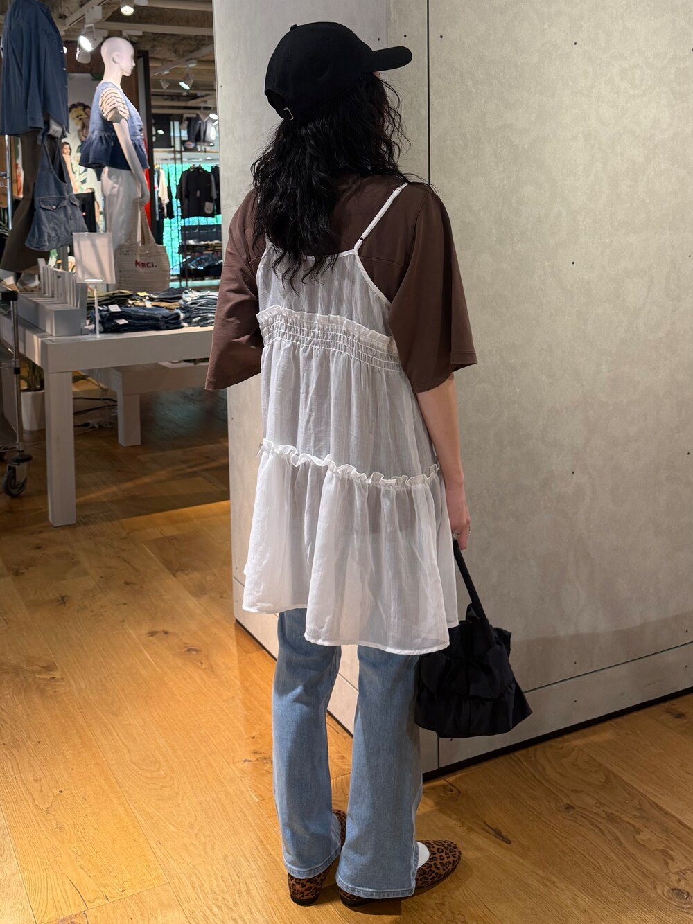 ブルー系のデニムパンツ、ホワイト系のベスト、ブラウン系のTシャツ/カットソーを着用したレディースの夏コーディネートの2枚目の写真