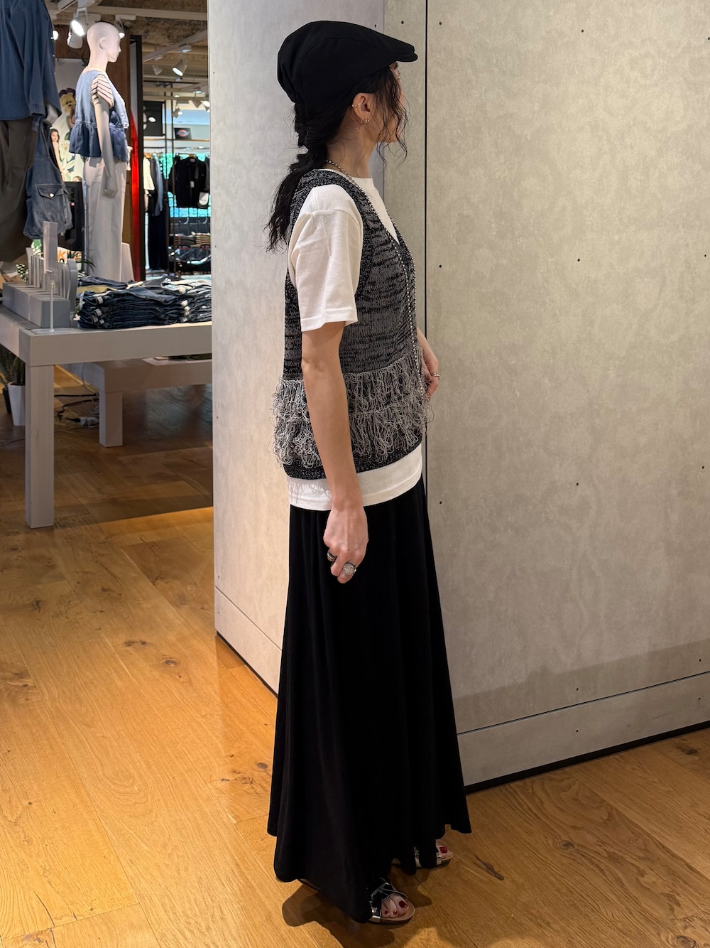 ブラック系のスカート、ブラック系のベスト、ホワイト系のTシャツ/カットソーを着用したレディースの夏コーディネートの4枚目の写真