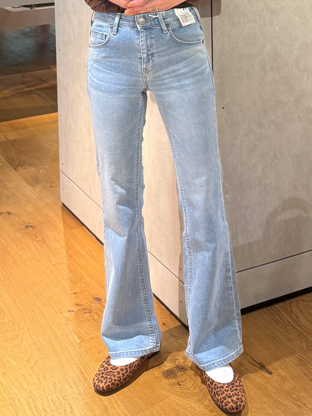 ブルー系のデニムパンツ、ホワイト系のベスト、ブラウン系のTシャツ/カットソーを着用したレディースの夏コーディネートの4枚目の写真