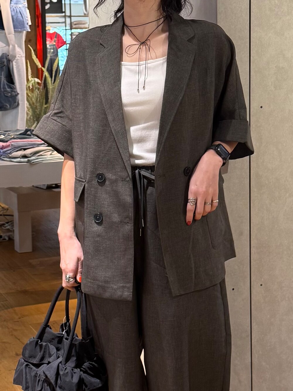 グレー系のその他パンツ、グレー系のテーラードジャケット、ホワイト系のタンクトップを着用したレディースの春コーディネートの6枚目の写真