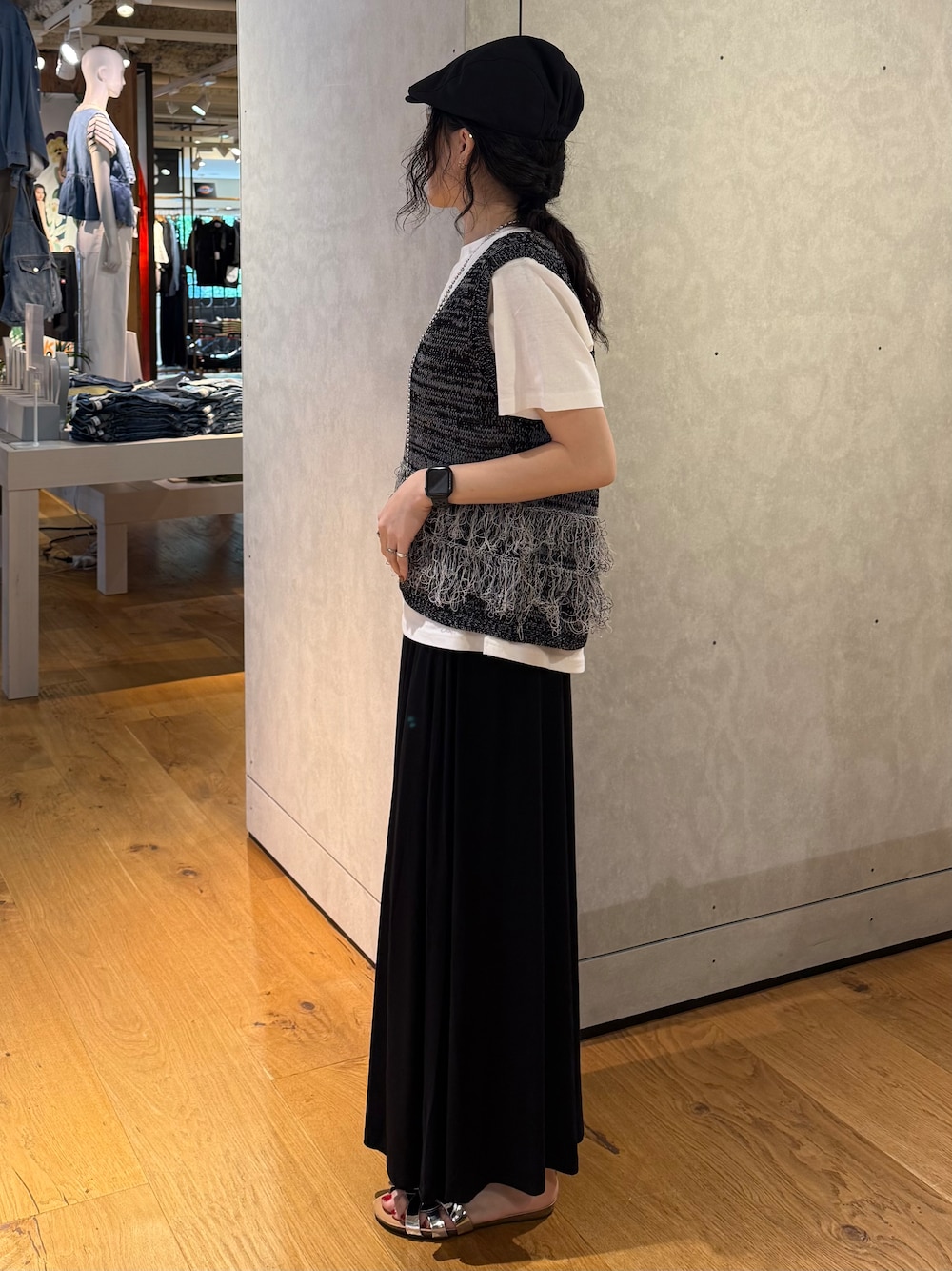 ブラック系のスカート、ブラック系のベスト、ホワイト系のTシャツ/カットソーを着用したレディースの夏コーディネートの2枚目の写真