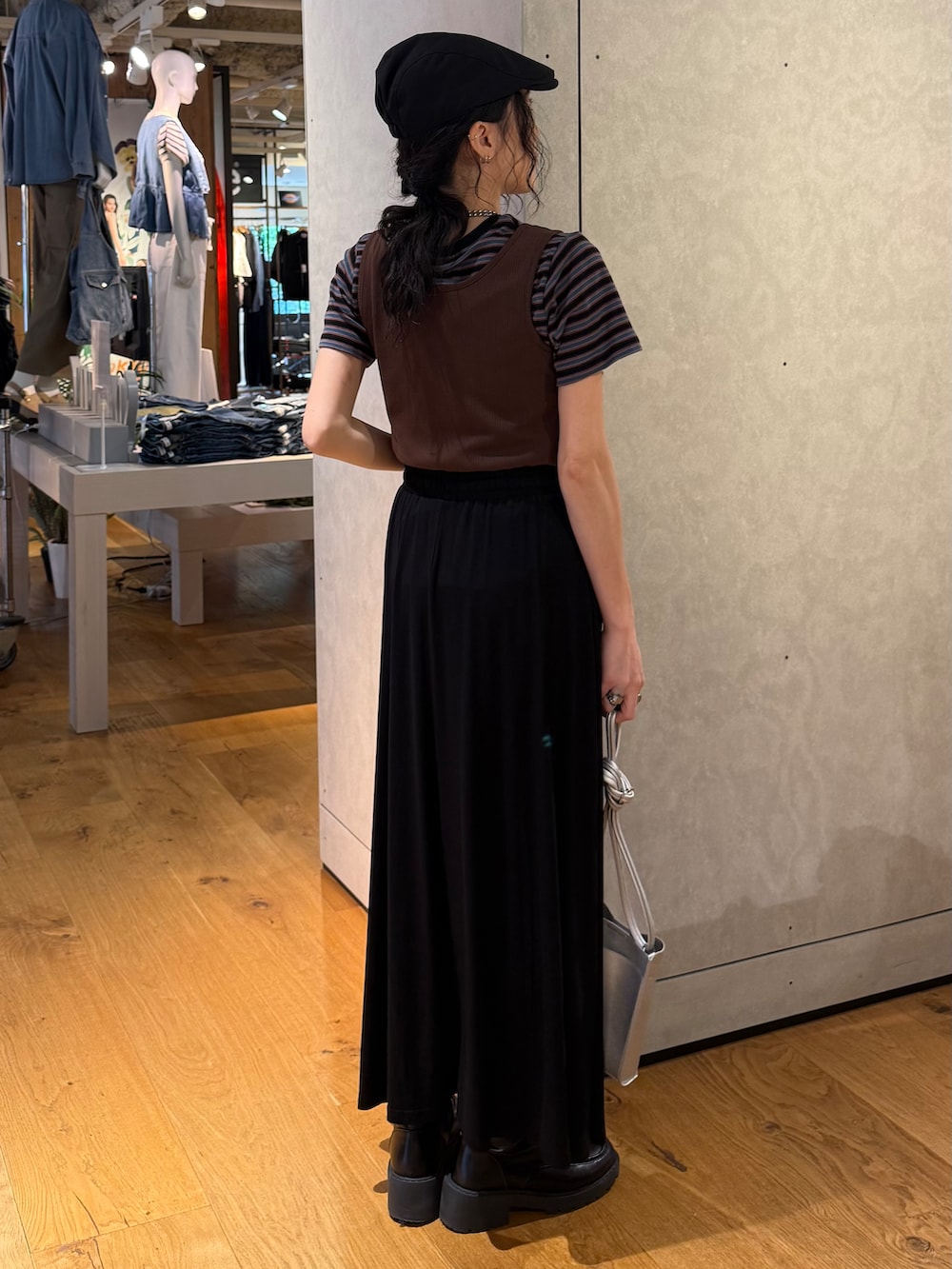 ブラック系のスカート、ブルー系のTシャツ/カットソー、ブラウン系のタンクトップを着用したレディースの夏コーディネートの3枚目の写真