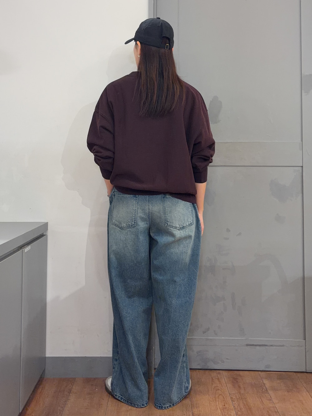 ブルー系のデニムパンツ、レッド系のスウェットを着用したレディースの秋コーディネートの3枚目の写真