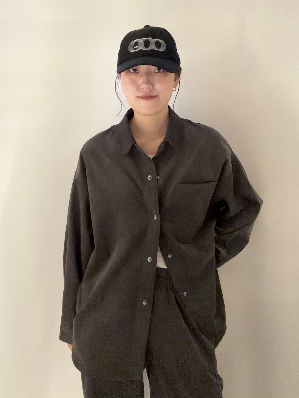 グレー系のシャツ/ブラウス、グレー系のその他パンツ、ブラック系のキャップを着用したレディースの秋コーディネートの5枚目の写真