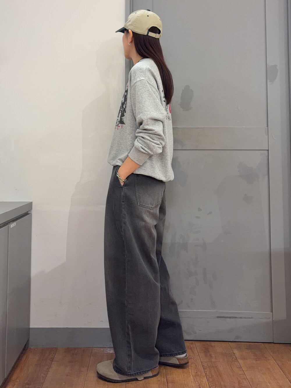 グレー系のTシャツ/カットソー、ブラック系のその他パンツ、グリーン系のキャップを着用したレディースの秋コーディネートの2枚目の写真