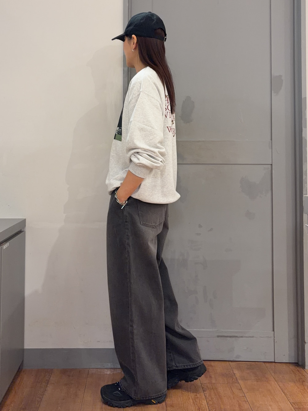 ベージュ系のニット/セーター、ブラック系のデニムパンツ、ブラック系のキャップを着用したレディースの秋コーディネートの2枚目の写真