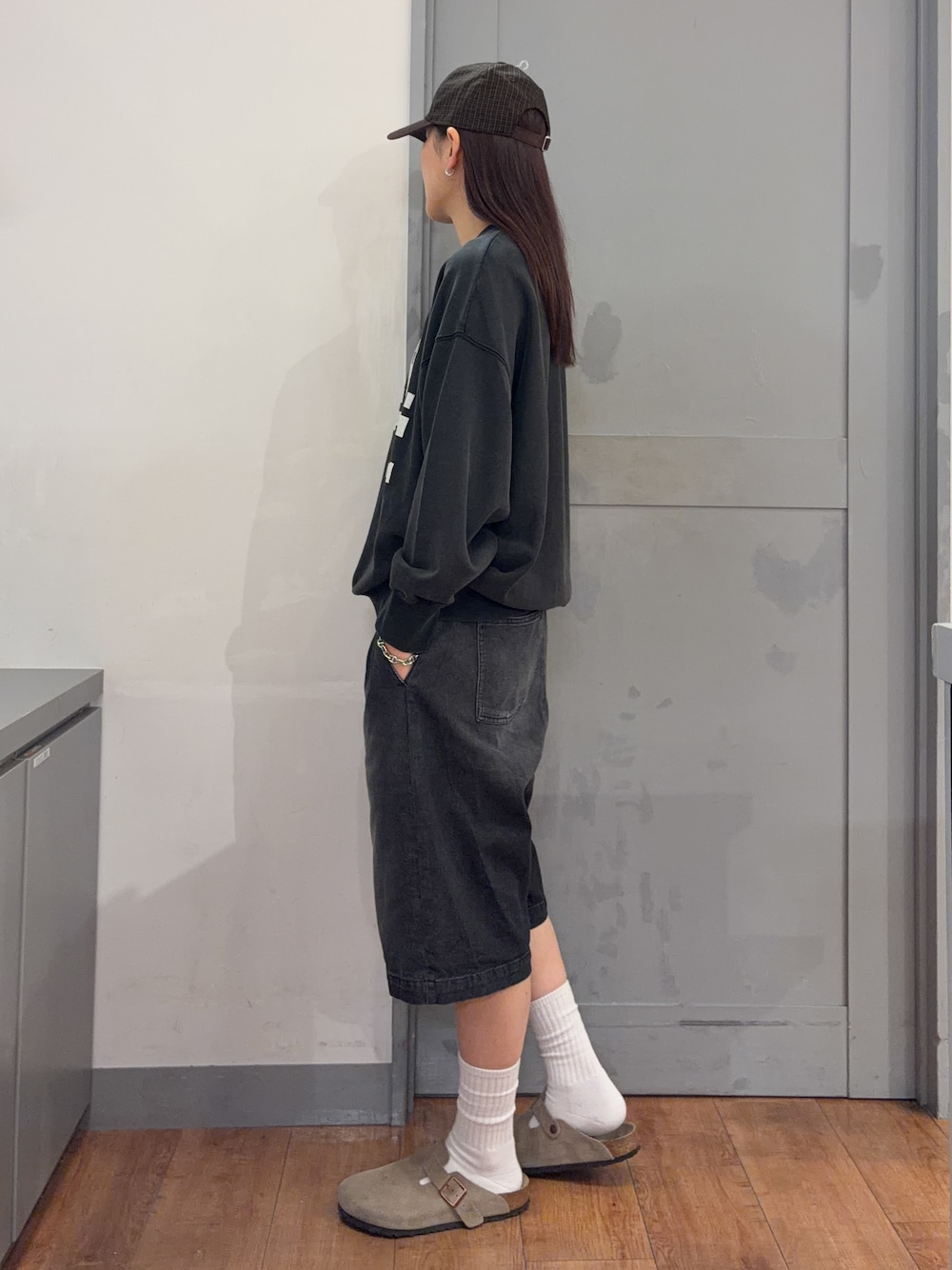 グレー系のスウェット、ブラック系のその他パンツ、ブラウン系のキャップを着用したレディースの秋コーディネートの2枚目の写真