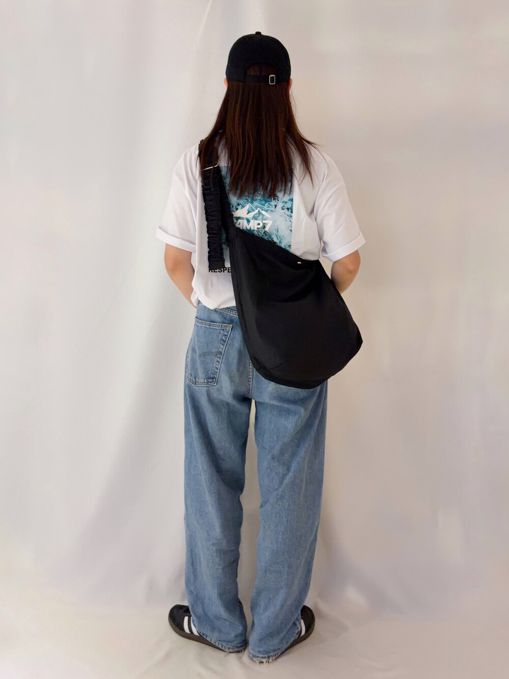 ホワイト系のTシャツ/カットソー、ブラック系のショルダーバッグ、ブラック系のキャップを着用したレディースの夏コーディネートの3枚目の写真