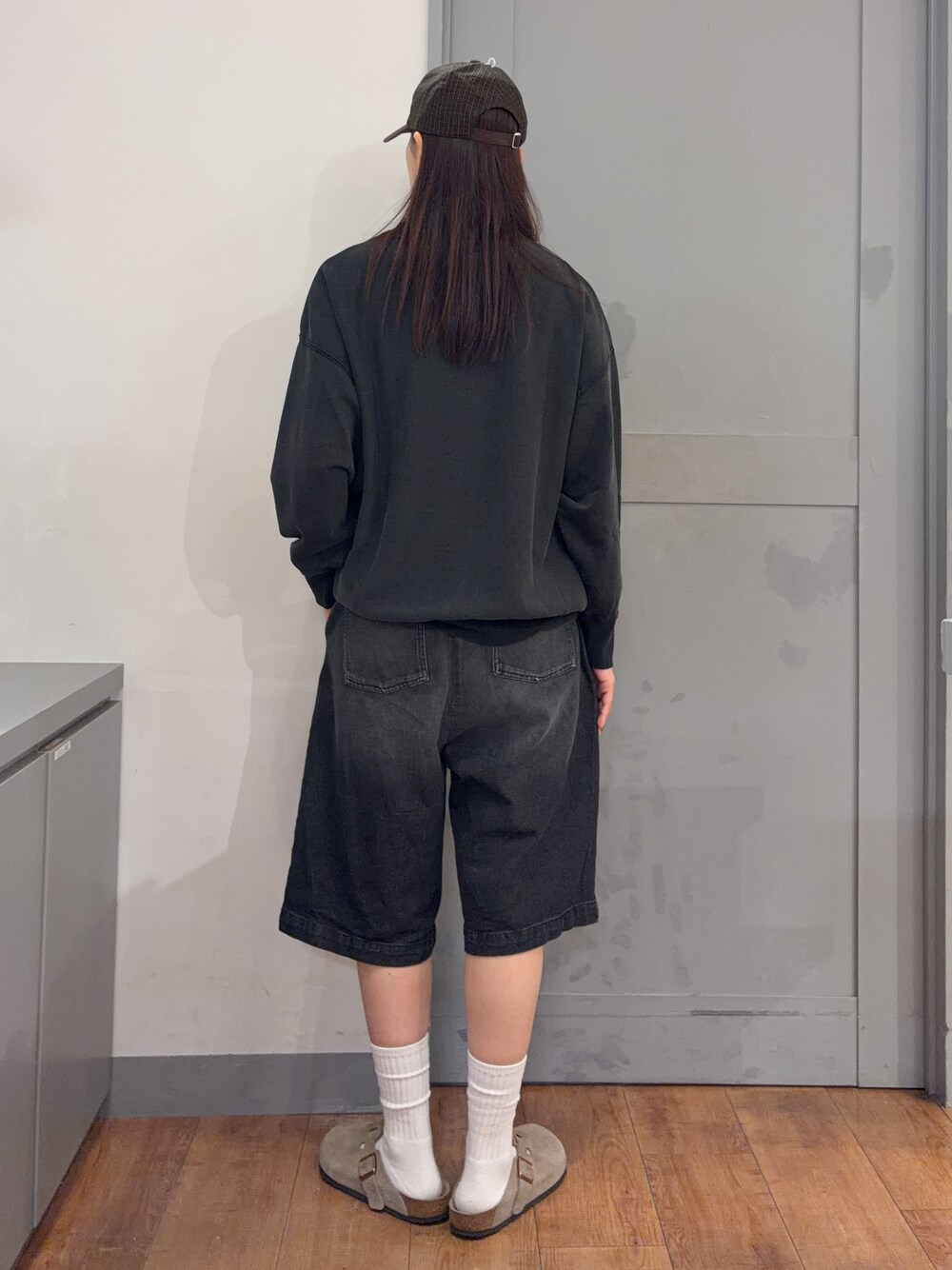 グレー系のスウェット、ブラック系のその他パンツ、ブラウン系のキャップを着用したレディースの秋コーディネートの3枚目の写真