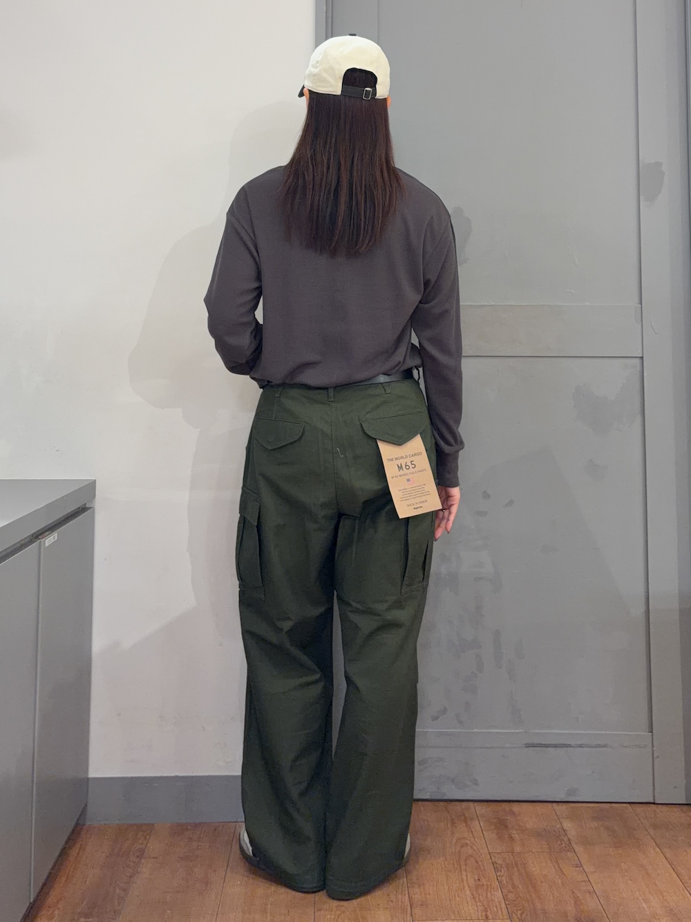 グリーン系のその他パンツ、グレー系のTシャツ/カットソー、グレー系のキャップを着用したレディースの秋コーディネートの3枚目の写真