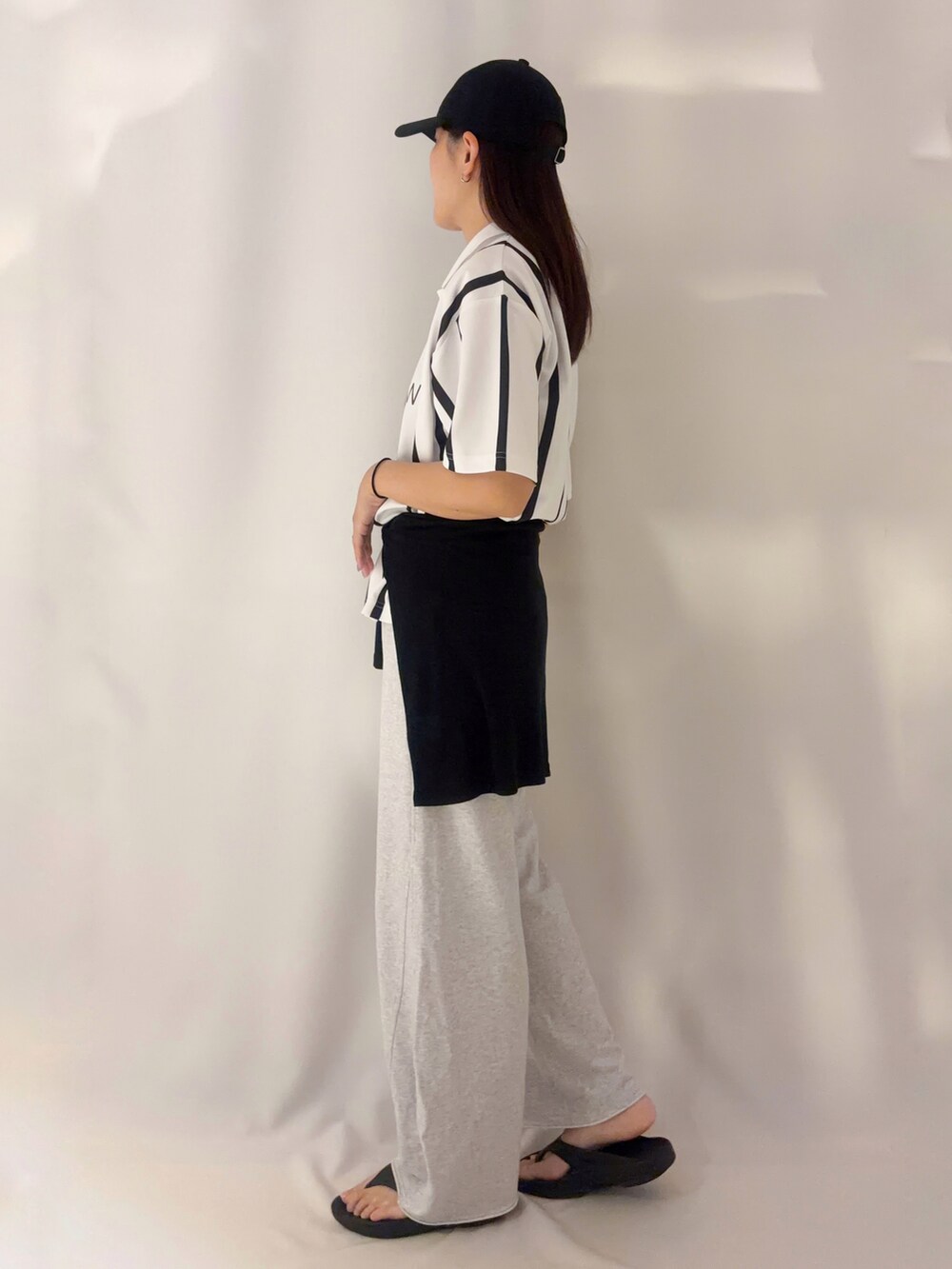 グレー系のその他パンツ、ブラック系のキャップを着用したレディースの夏コーディネートの2枚目の写真