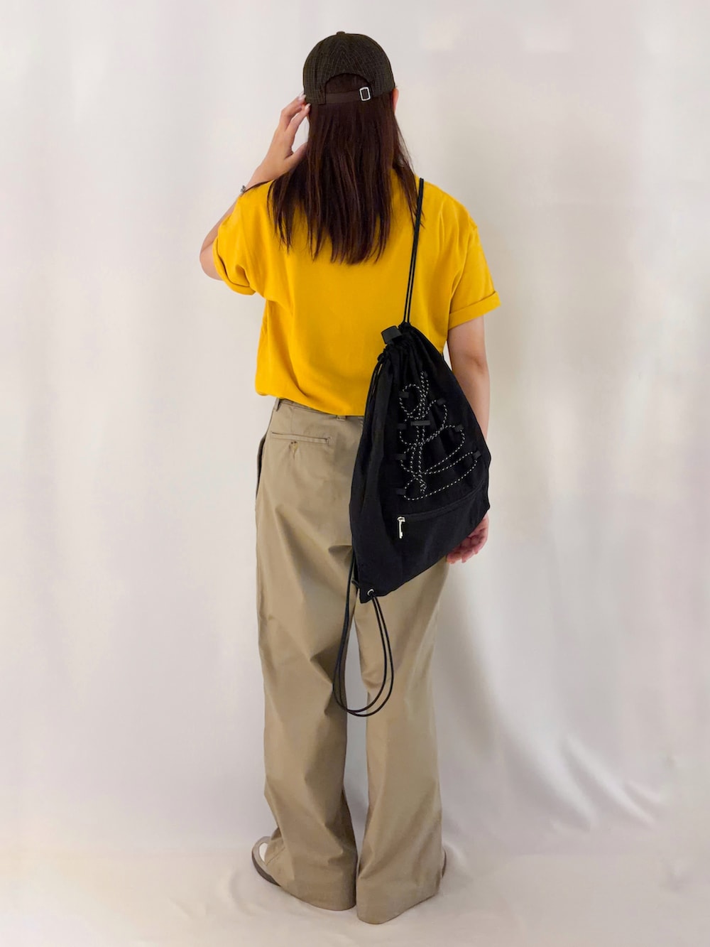 イエロー系のTシャツ/カットソー、ブラック系のショルダーバッグを着用したレディースの夏コーディネートの3枚目の写真