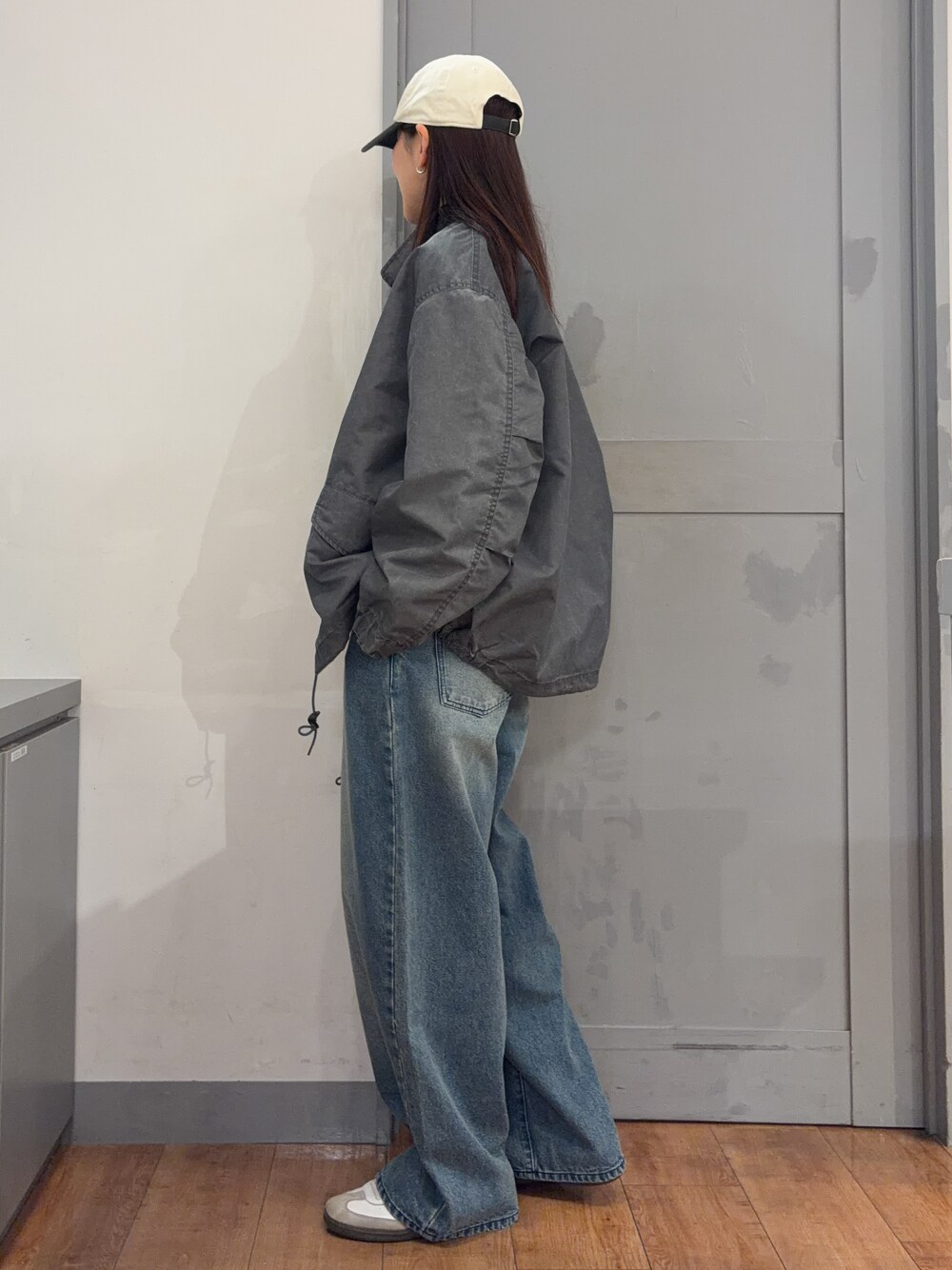 グレー系のミリタリージャケット、グレー系のTシャツ/カットソー、ブルー系のデニムパンツを着用したレディースの秋コーディネートの3枚目の写真