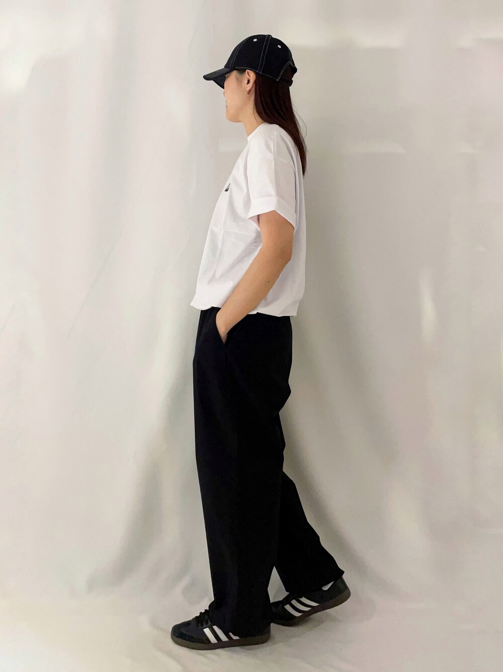 ホワイト系のTシャツ/カットソー、ブラック系のその他パンツ、ブラック系のキャップを着用したレディースの春コーディネートの3枚目の写真