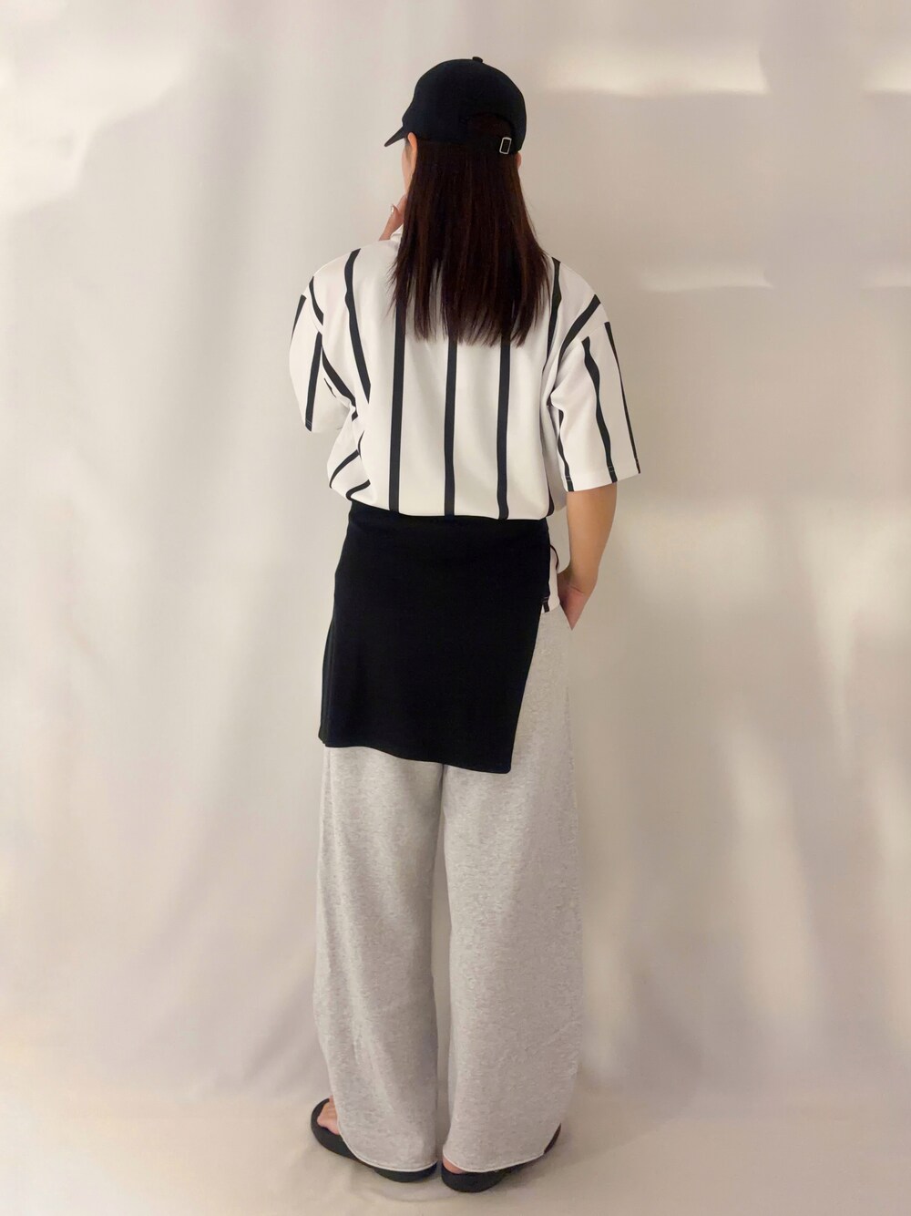 グレー系のその他パンツ、ブラック系のキャップを着用したレディースの夏コーディネートの3枚目の写真