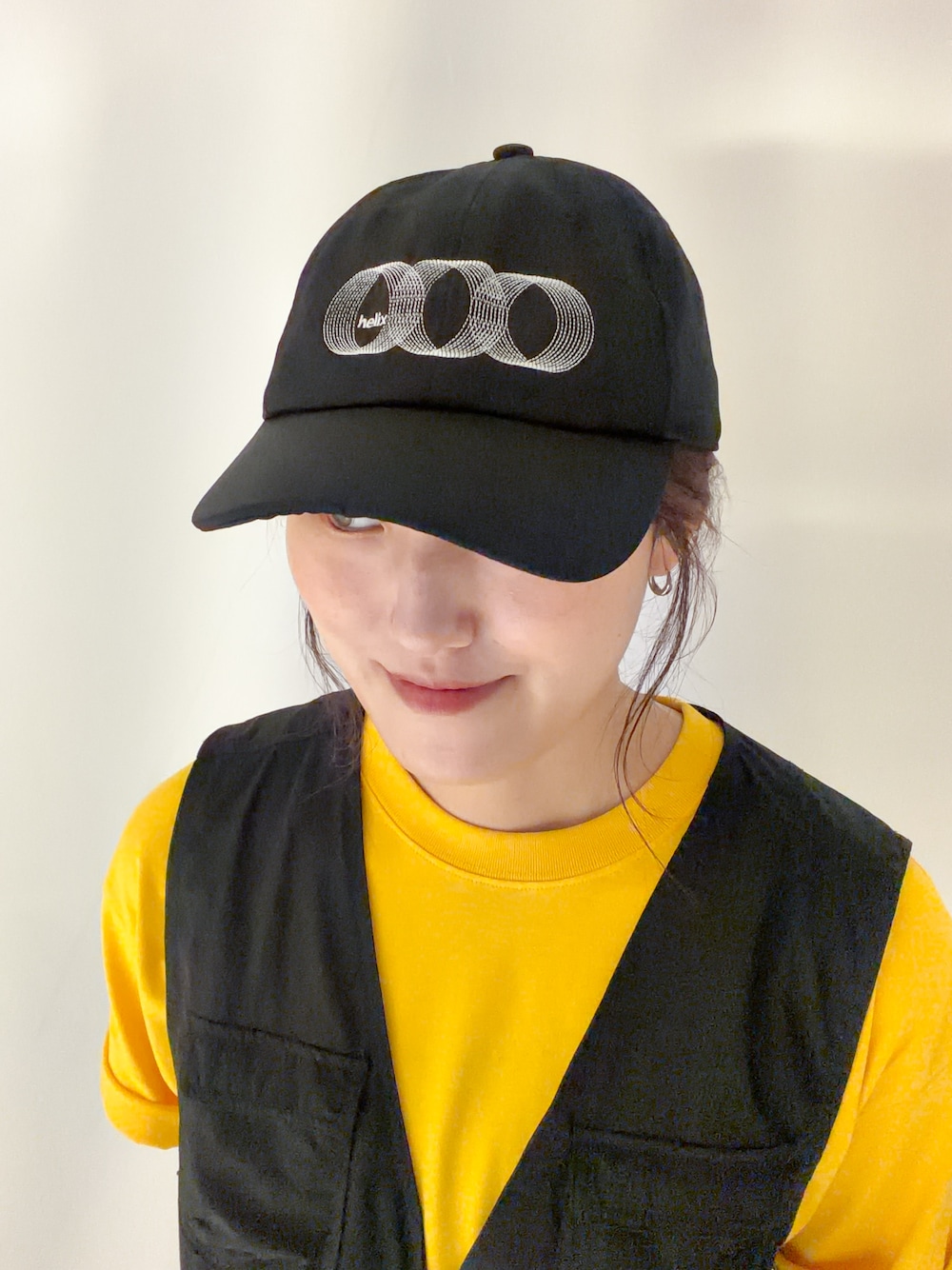 ブラック系のショルダーバッグ、イエロー系のTシャツ/カットソー、ブラック系のキャップを着用したレディースの夏コーディネートの6枚目の写真