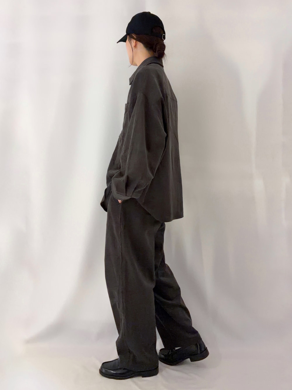 グレー系のシャツ/ブラウス、グレー系のその他パンツ、ブラック系のキャップを着用したレディースの秋コーディネートの2枚目の写真