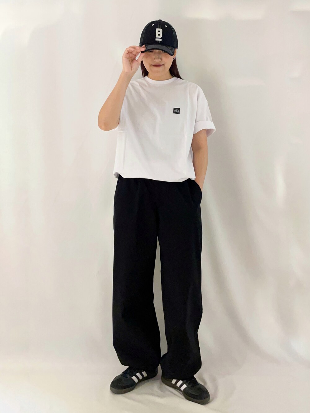 ホワイト系のTシャツ/カットソー、ブラック系のその他パンツ、ブラック系のキャップを着用したレディースの春コーディネートの2枚目の写真