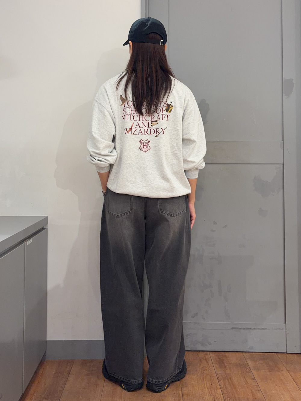 ベージュ系のニット/セーター、ブラック系のデニムパンツ、ブラック系のキャップを着用したレディースの秋コーディネートの3枚目の写真