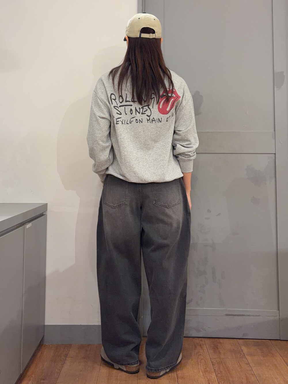 グレー系のTシャツ/カットソー、ブラック系のその他パンツ、グリーン系のキャップを着用したレディースの秋コーディネートの3枚目の写真