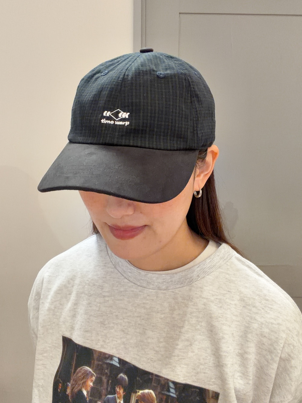 ベージュ系のニット/セーター、ブラック系のデニムパンツ、ブラック系のキャップを着用したレディースの秋コーディネートの7枚目の写真