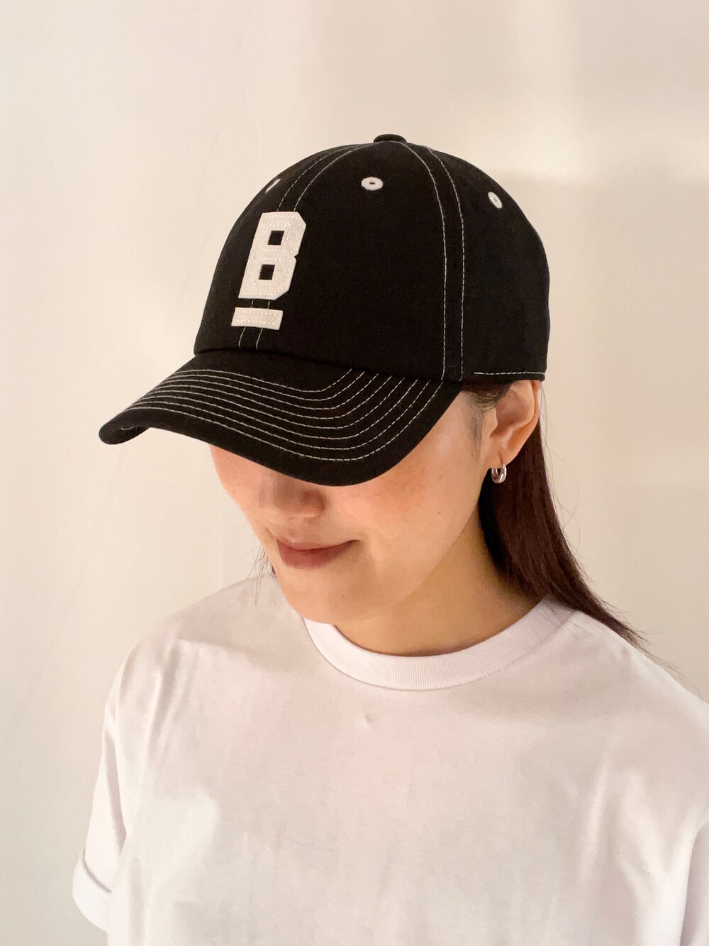ホワイト系のTシャツ/カットソー、ブラック系のその他パンツ、ブラック系のキャップを着用したレディースの春コーディネートの8枚目の写真