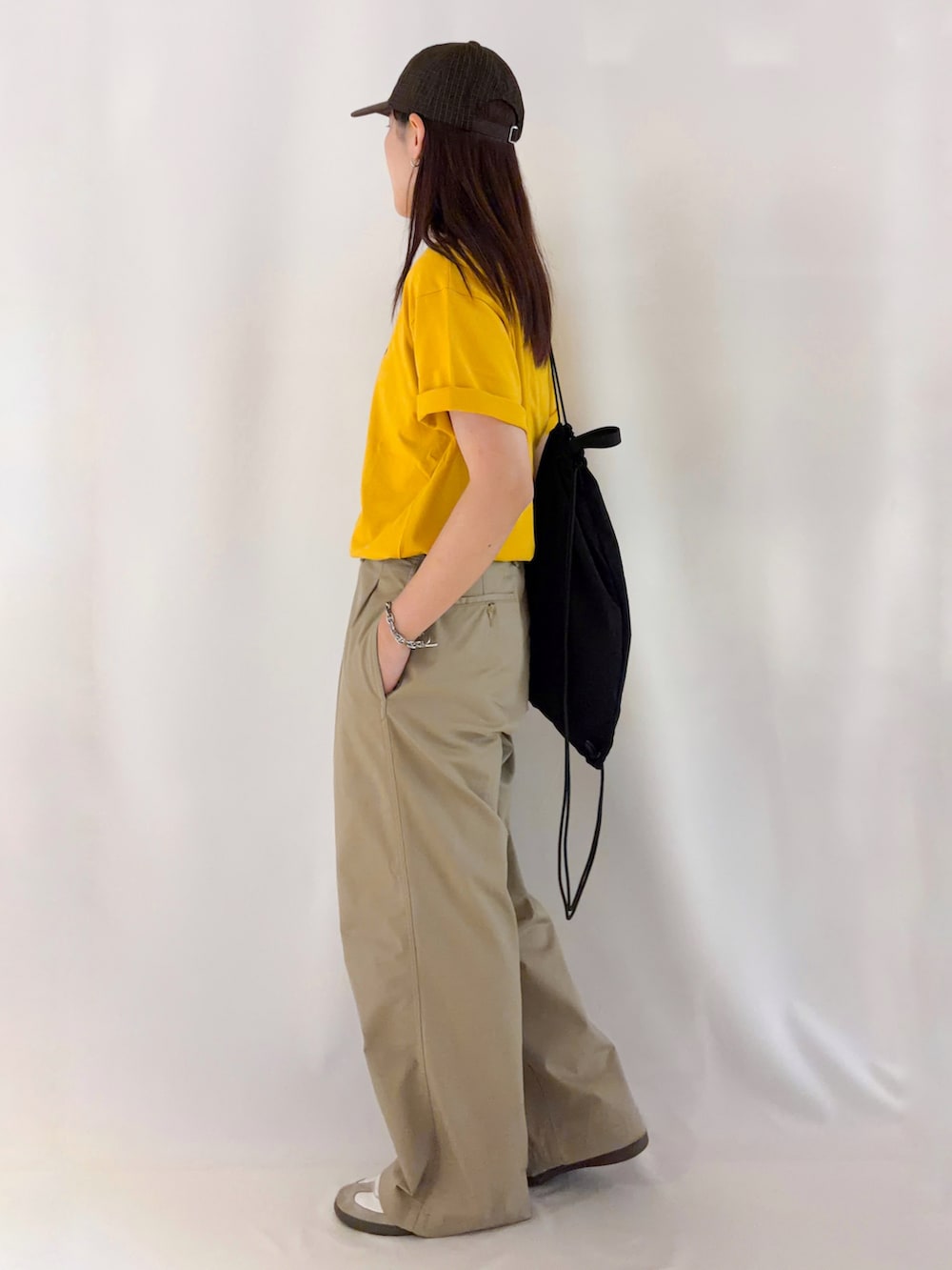 イエロー系のTシャツ/カットソー、ブラック系のショルダーバッグを着用したレディースの夏コーディネートの2枚目の写真