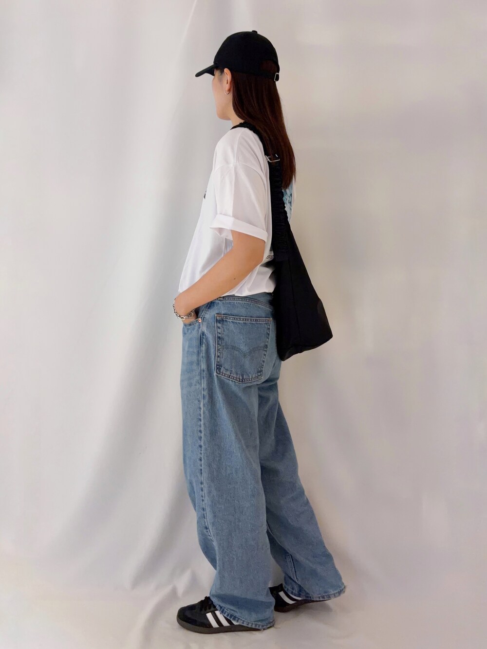 ホワイト系のTシャツ/カットソー、ブラック系のショルダーバッグ、ブラック系のキャップを着用したレディースの夏コーディネートの2枚目の写真