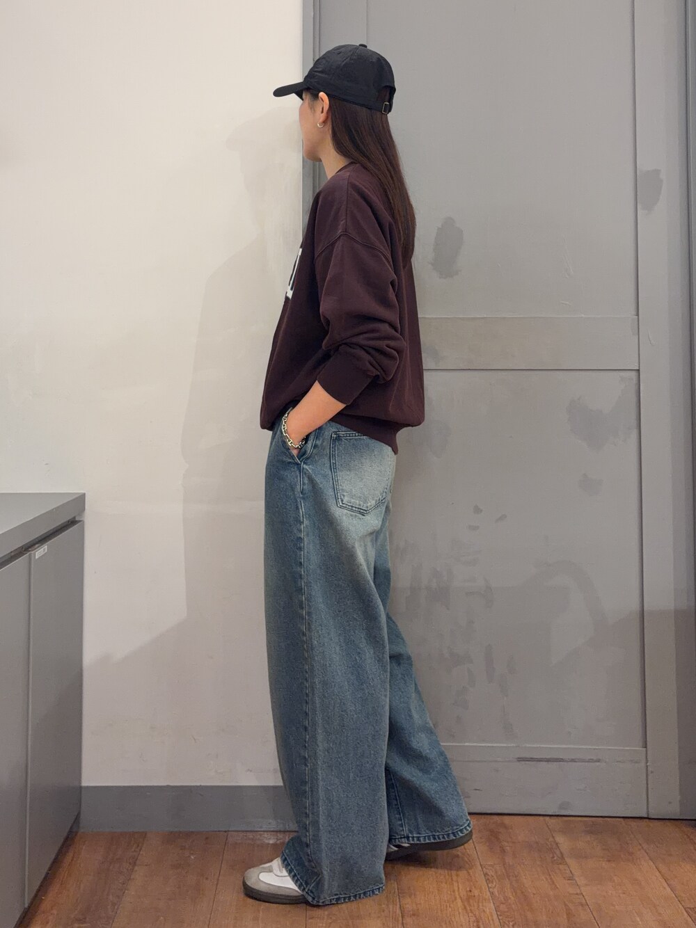 ブルー系のデニムパンツ、レッド系のスウェットを着用したレディースの秋コーディネートの2枚目の写真