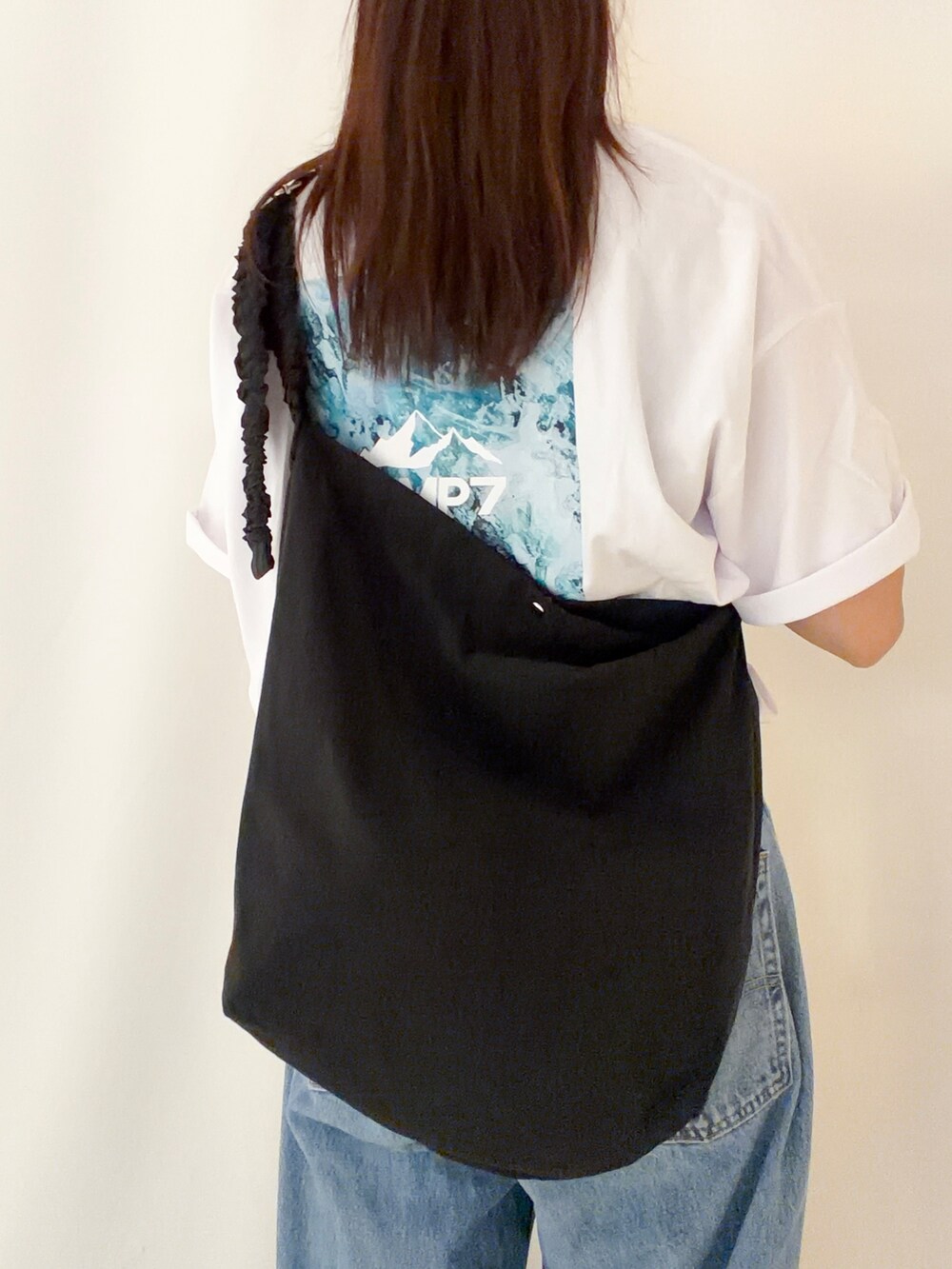 ホワイト系のTシャツ/カットソー、ブラック系のショルダーバッグ、ブラック系のキャップを着用したレディースの夏コーディネートの6枚目の写真
