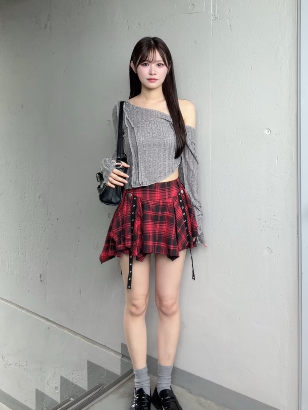 レッド系のスカート、グレー系のTシャツ/カットソーを着用したレディースの秋コーディネートの2枚目の写真