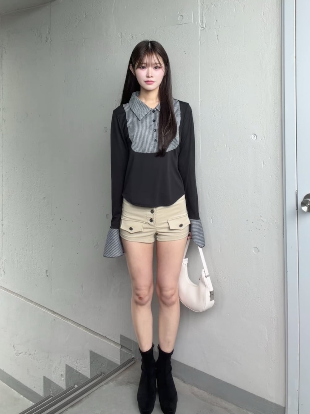 ベージュ系のパンツ、ブラック系のシャツ/ブラウスを着用したレディースの秋コーディネートの2枚目の写真