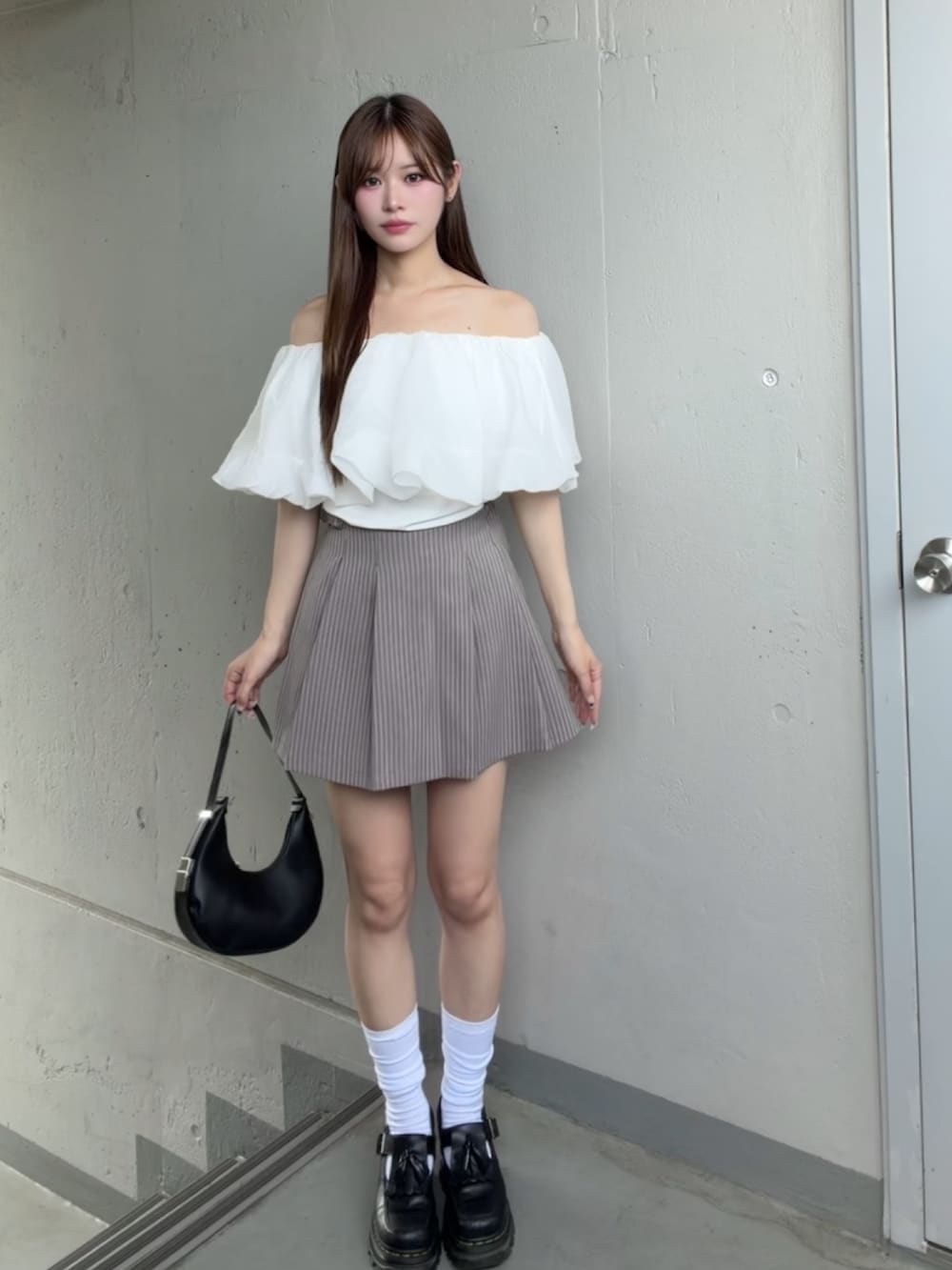 グレー系のスカート、ホワイト系のTシャツ/カットソーを着用したレディースの夏コーディネートの2枚目の写真
