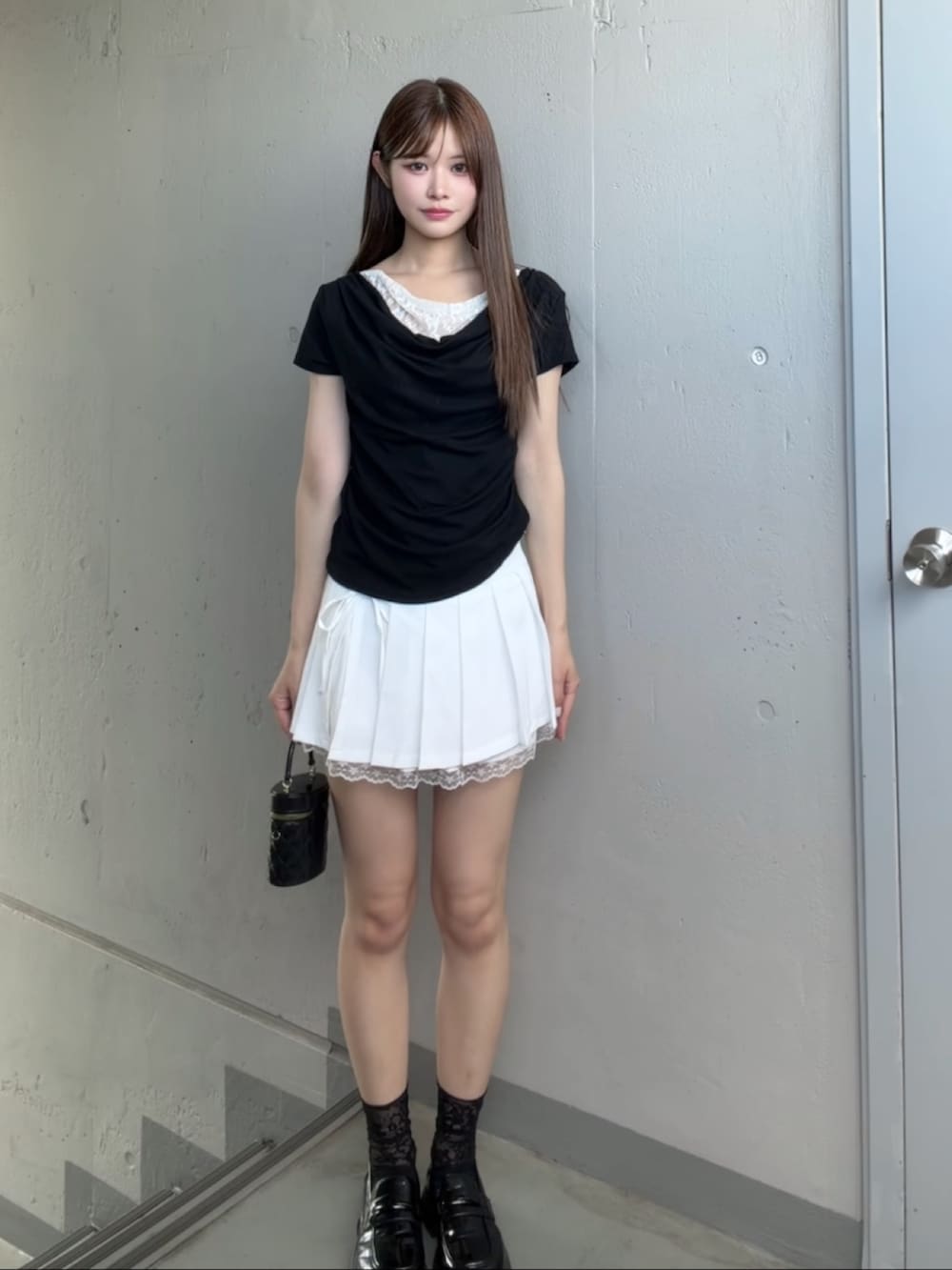 ホワイト系のスカート、ブラック系のTシャツ/カットソーを着用したレディースの夏コーディネートの2枚目の写真