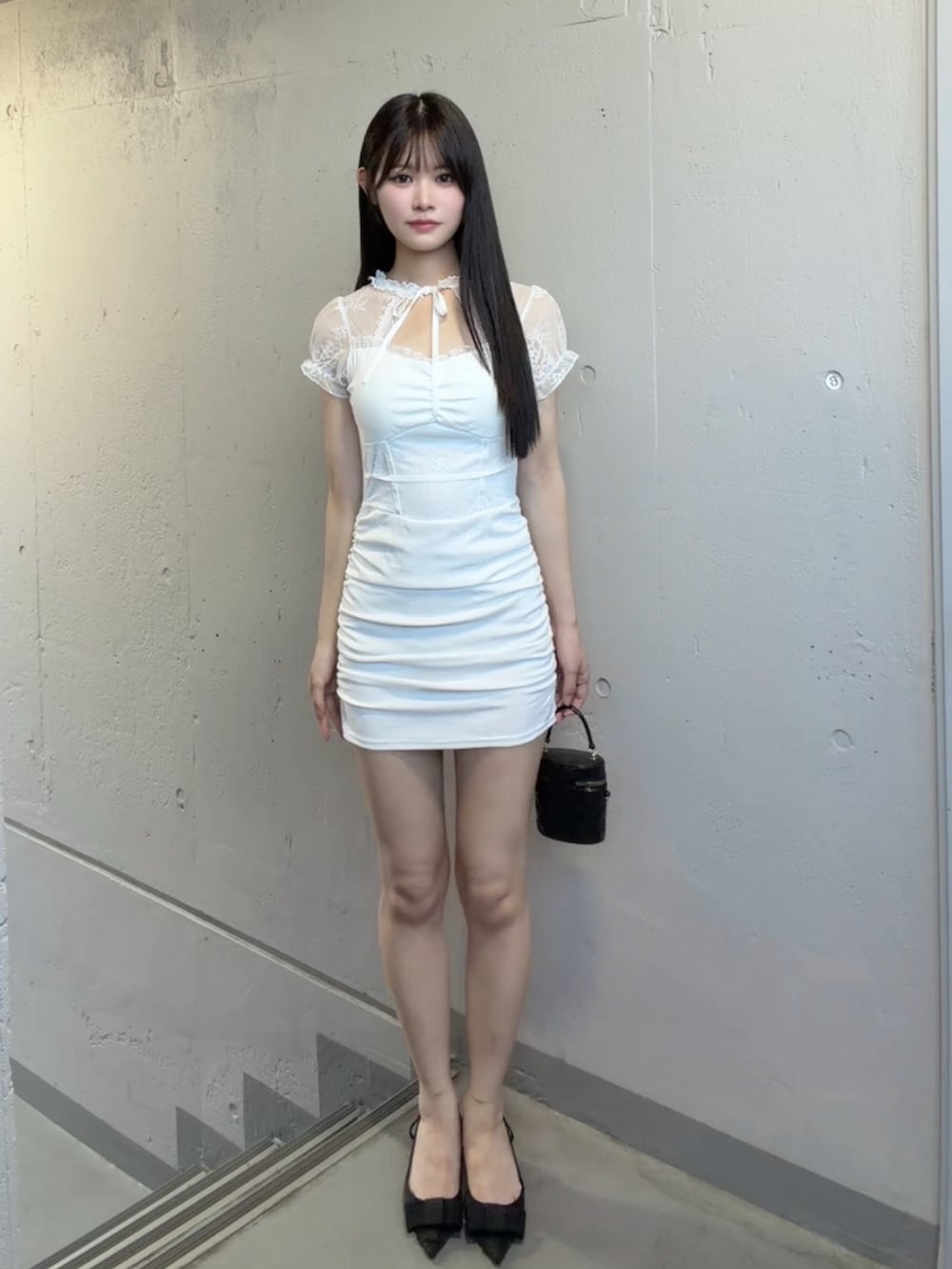 ホワイト系のワンピース、ブラック系のパンプスを着用したレディースの夏コーディネートの2枚目の写真