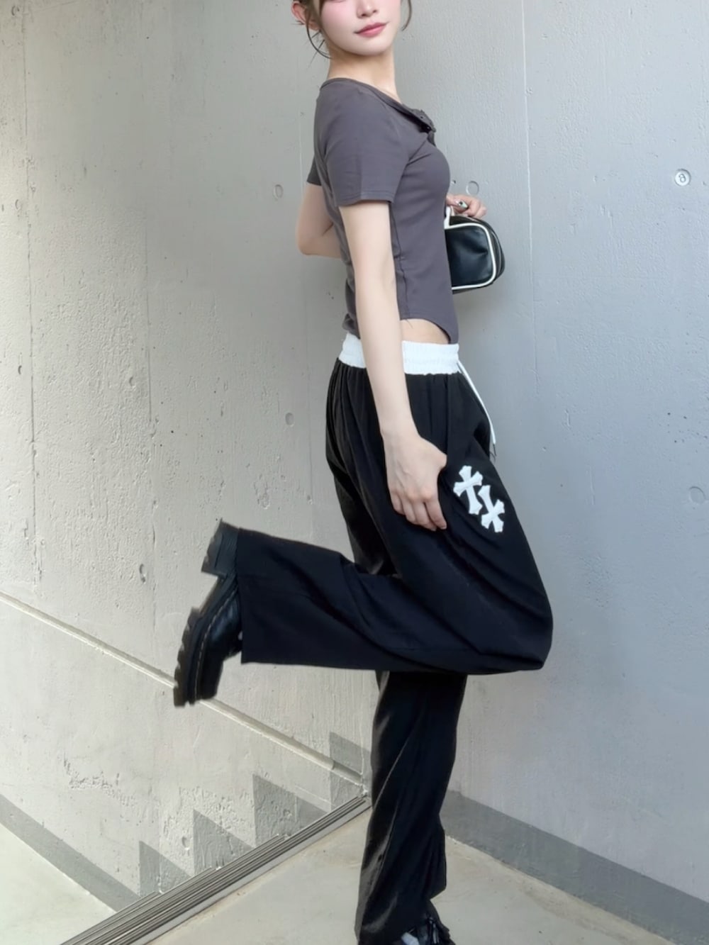 グレー系のTシャツ/カットソー、ブラック系のスウェットパンツ、ブラック系のその他シューズを着用したレディースの夏コーディネートの2枚目の写真