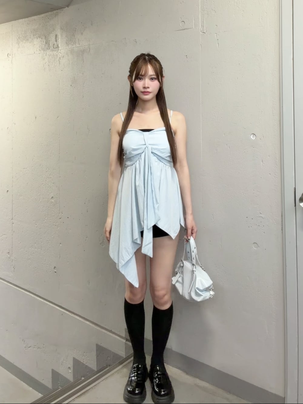 ブラック系のスウェットパンツ、ブルー系のショルダーバッグ、ブルー系のキャミソールを着用したレディースの夏コーディネートの2枚目の写真