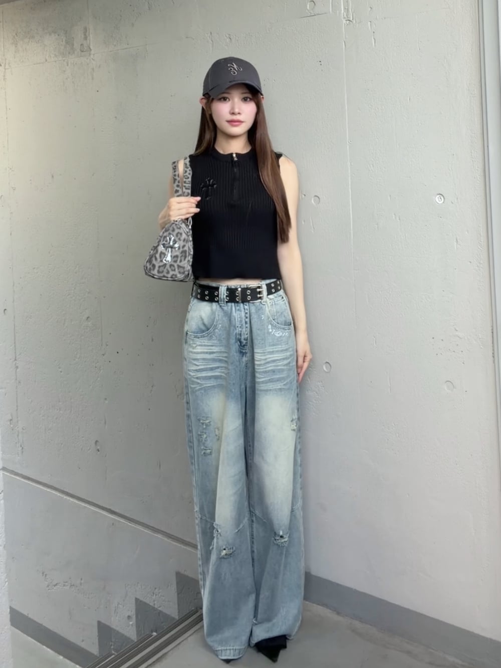 ブルー系のデニムパンツ、ブラック系のベスト、その他のショルダーバッグを着用したレディースの夏コーディネートの2枚目の写真