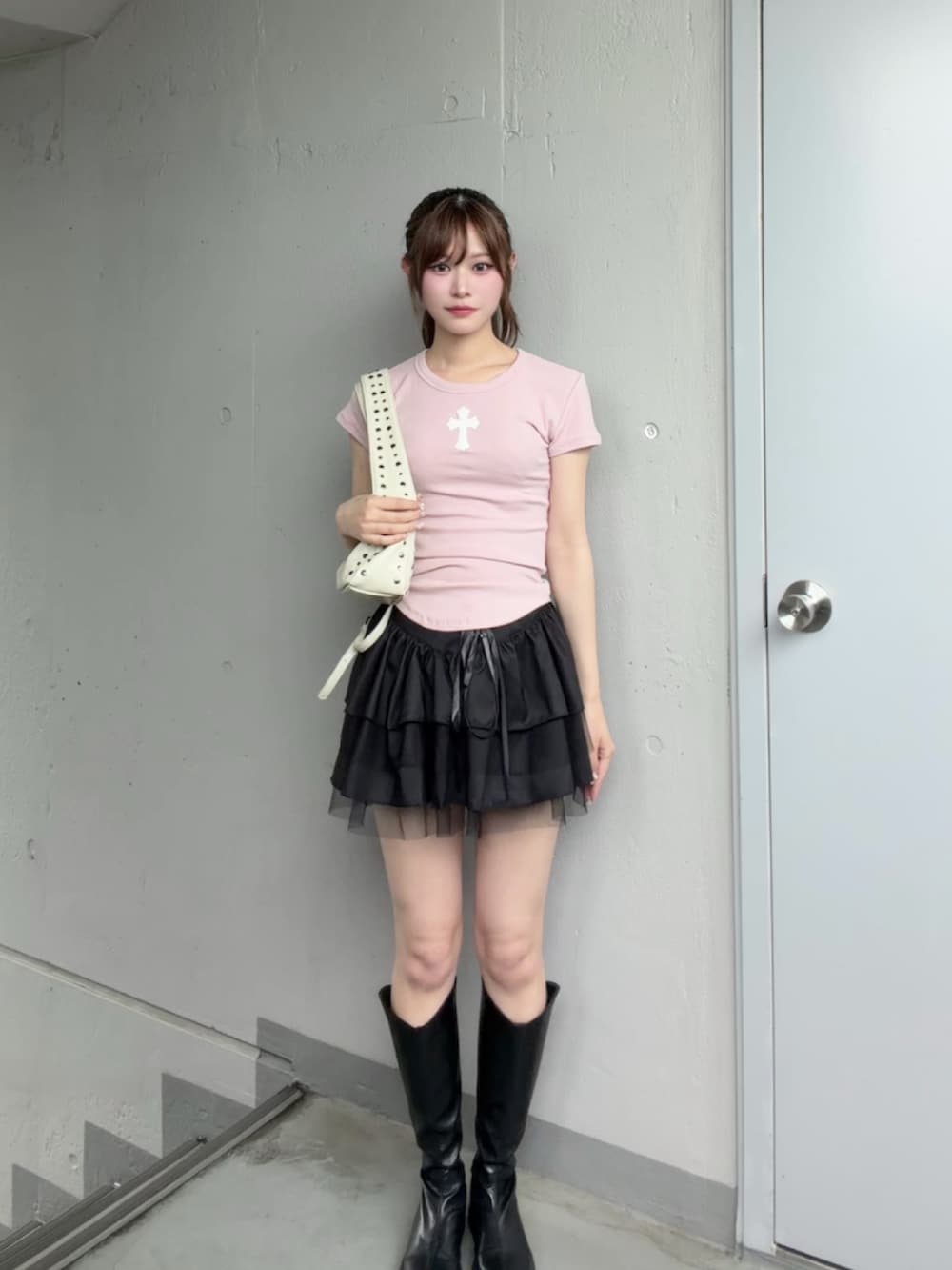 ピンク系のTシャツ/カットソー、ブラック系のスカート、ホワイト系のショルダーバッグを着用したレディースの夏コーディネートの2枚目の写真