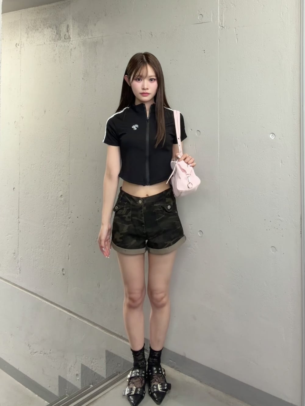 ブラック系のポロシャツ、グリーン系のデニムパンツ、ピンク系のショルダーバッグを着用したレディースの夏コーディネートの2枚目の写真