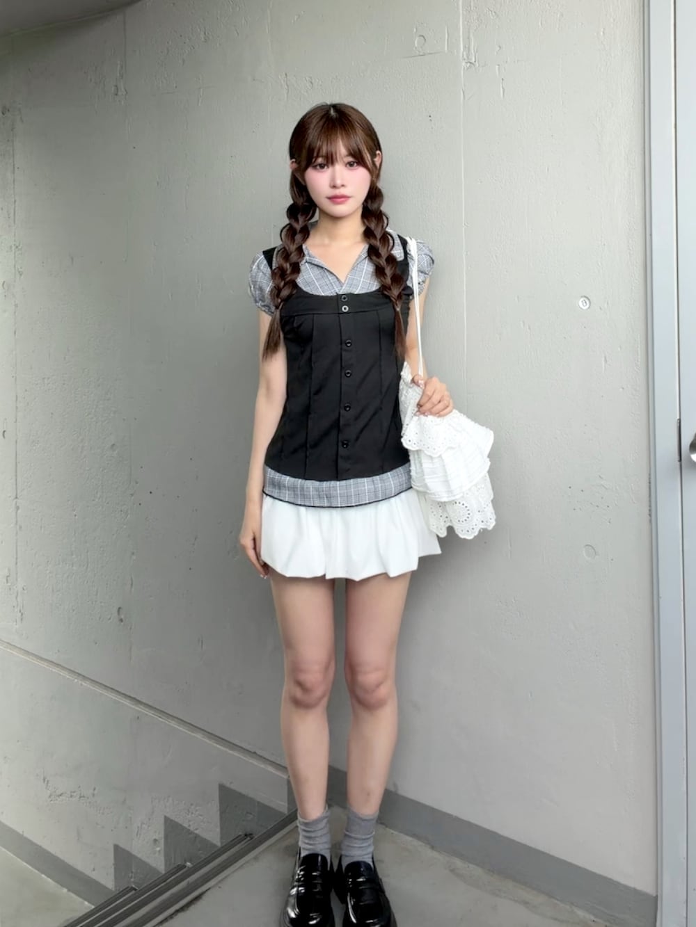 ホワイト系のスカート、ブラック系のシャツ/ブラウスを着用したレディースの夏コーディネートの2枚目の写真