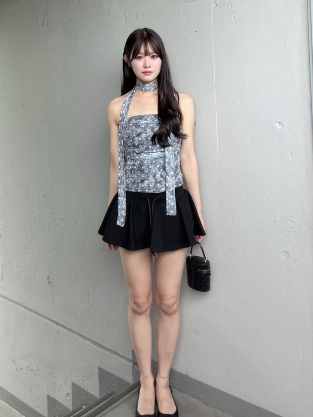 ブラック系のスカート、グレー系のチューブトップを着用したレディースの夏コーディネートの2枚目の写真